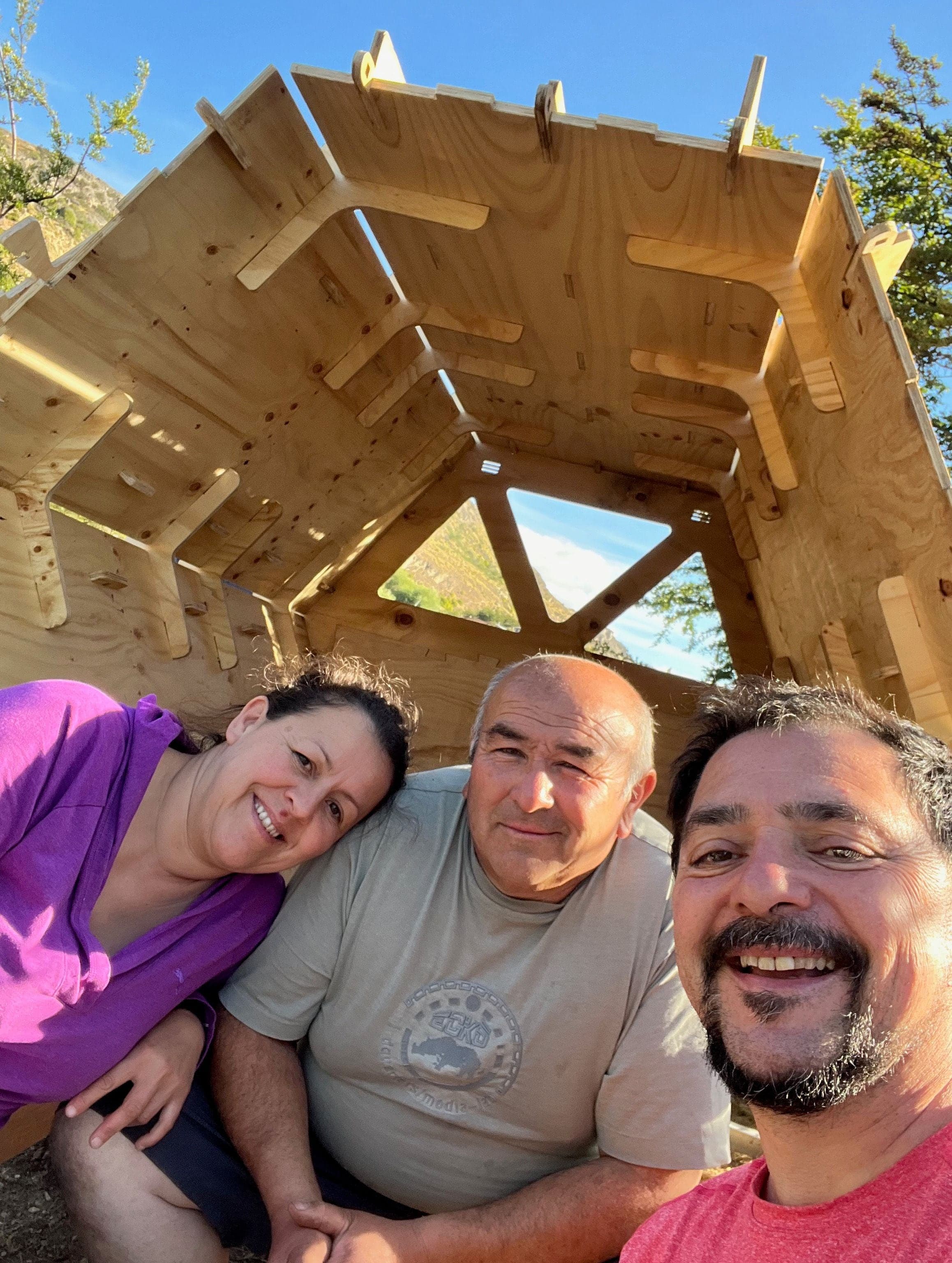 Jolett e Atilio sorridono sotto il tetto di legno di un rifugio