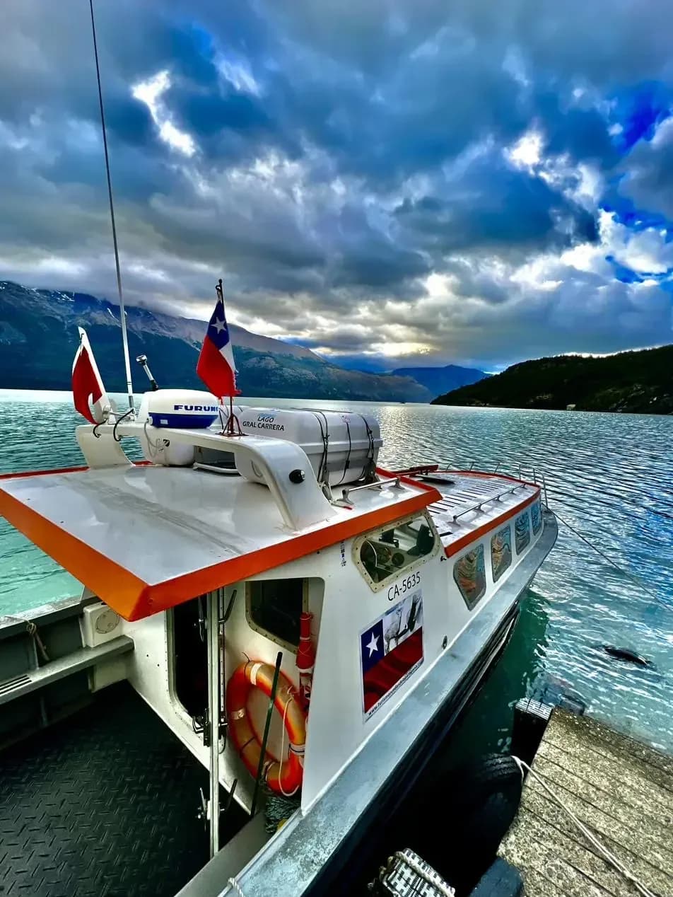 L'imbarcazione di Ruedas de la Patagonia ormeggiata al molo, sotto un cielo carico