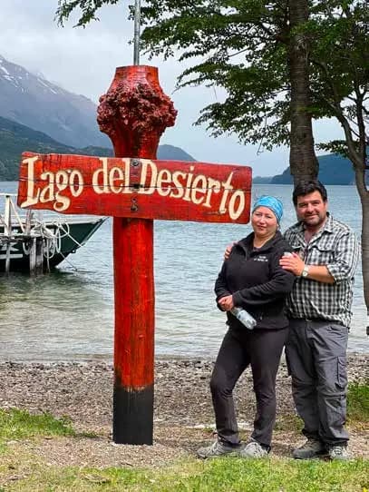 Marcus e Angélica accanto al cartello di legno del Lago del Desierto