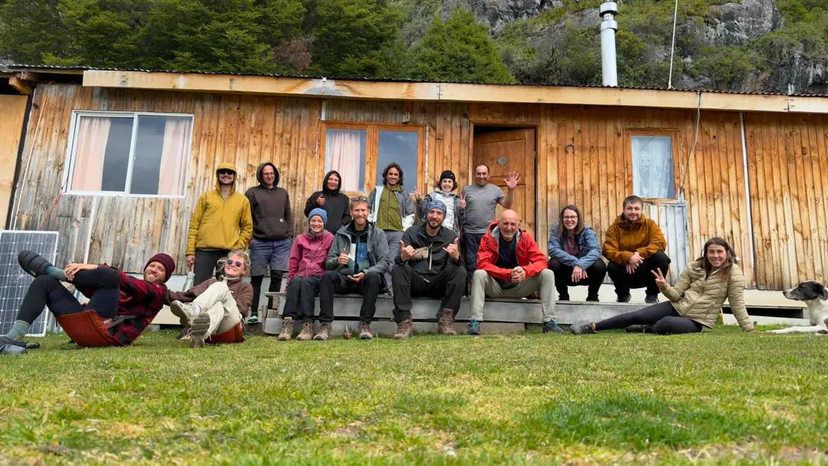 Un gruppo di viaggiatori seduti davanti a una casa di legno a Candelario Mancilla