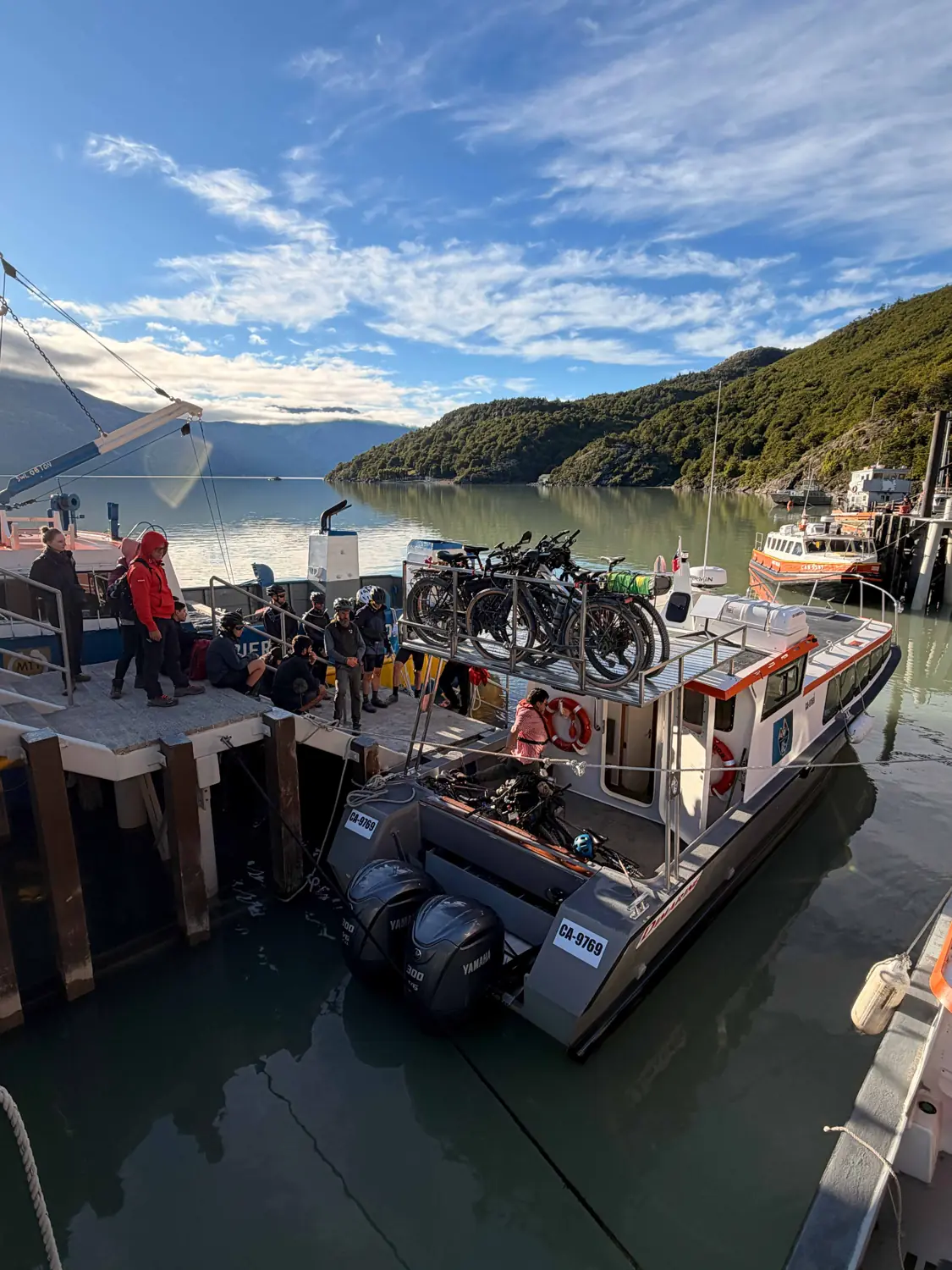 Una barca di Ruedas de la Patagonia ormeggiata al molo, con le bici a bordo