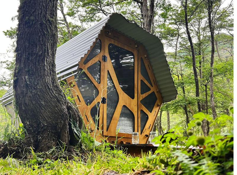 Un micro-refugio de madera entre los árboles del bosque